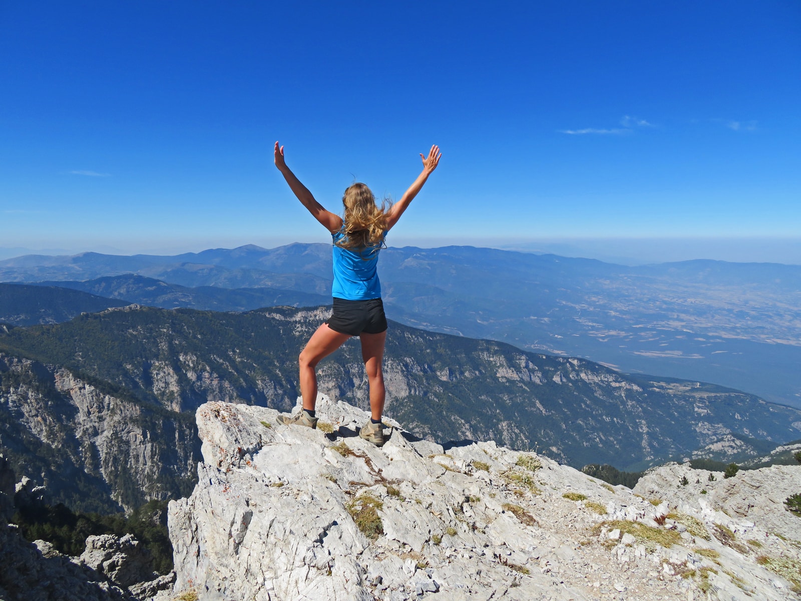 Frau jubelnd auf Bergspitze